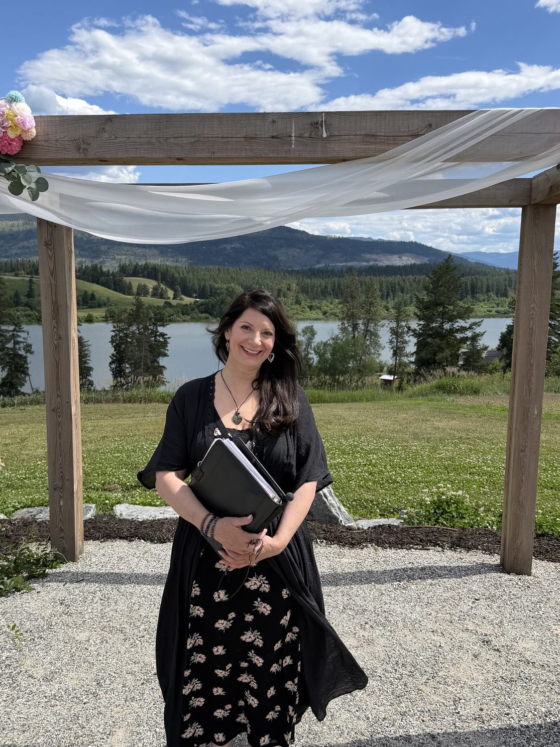Valerie under a wooden arbor with lake views