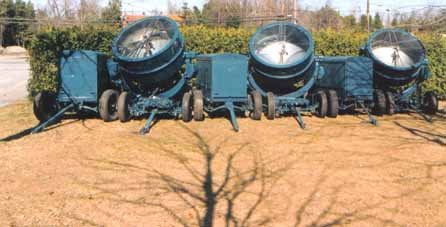Three searchlights lined up in daylight